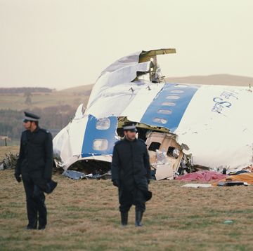 lockerbie, two police officers stand in front of an airplane wreckage in a field
