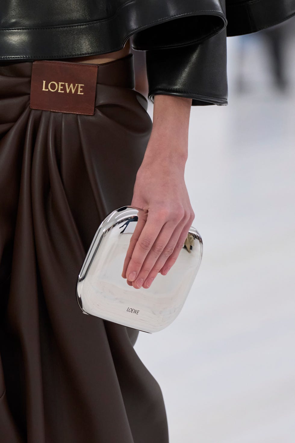 hand holding a metallic clutch showcasing fashion design