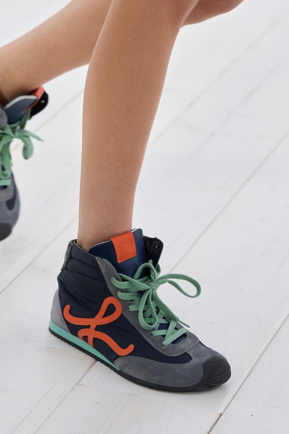 Sporty hightop sneaker with colorful accents displayed on a leg