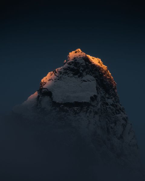 Zonnestralen beroeren de top van de berg Otertinden in de vallei Signaldalen