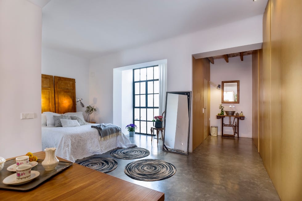 dormitorio rústico con baño en suite y muebles recuperados