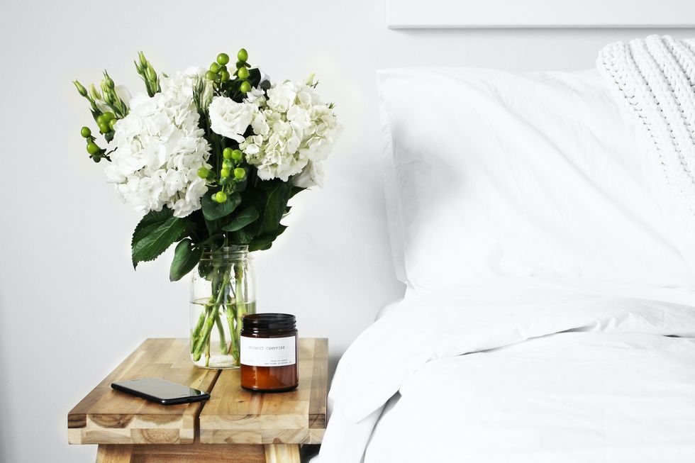 vase of assorted white flowers near a bed