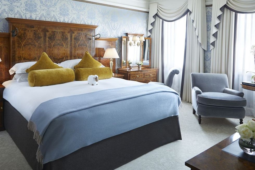 a bedroom with a bed and a blue chair at the goring