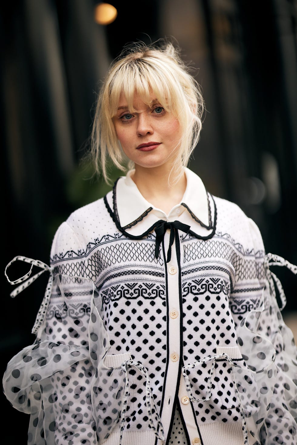 fashionable outfit featuring a patterned sweater and sheer sleeves best fringe haircuts london fashion week street style