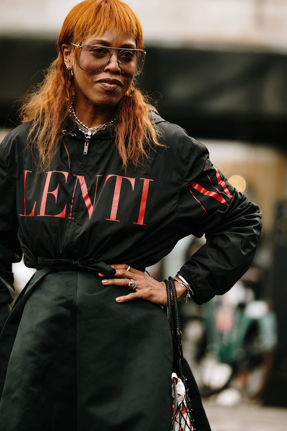 fashionable individual wearing a black jacket with bold red lettering best fringe haircuts london fashion week street style