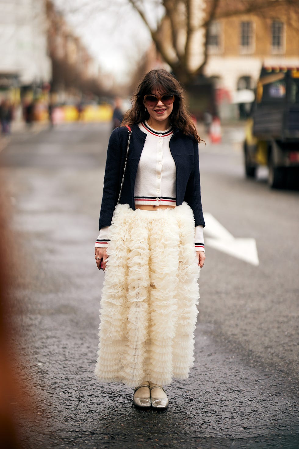 fashionable outfit featuring a cropped jacket and a ruffled skirt best fringe haircuts london fashion week street style