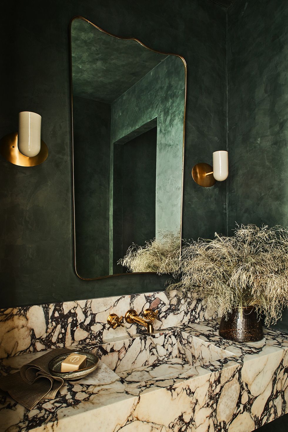 moody bathroom with green walls and marble sink
