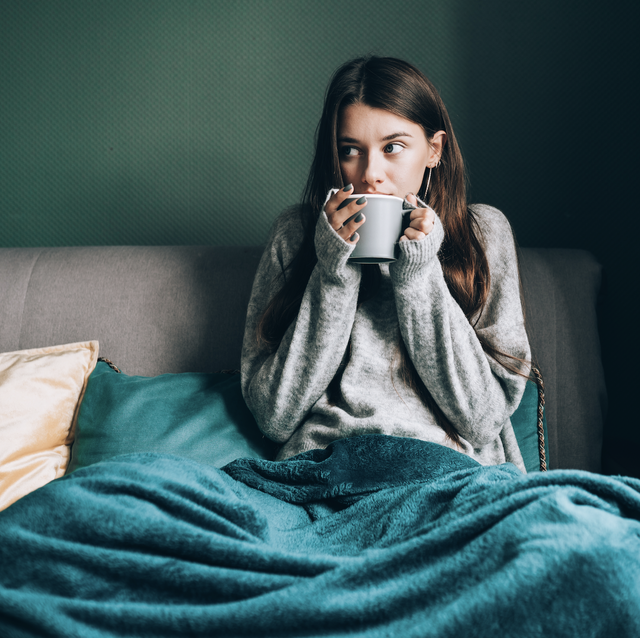 woman sipping coffee with a blanket