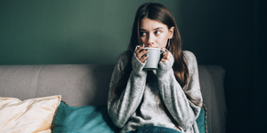 woman sipping coffee with a blanket