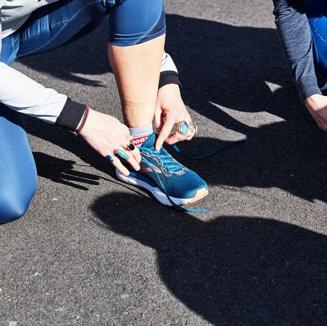 person tying their running shoe