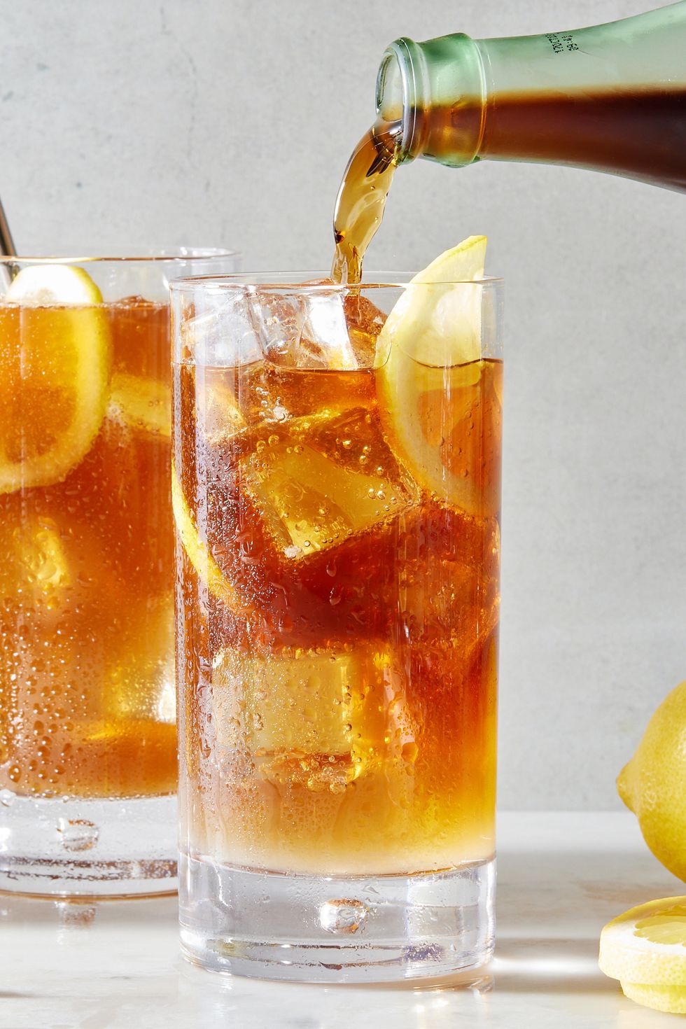 long island iced tea cocktail with lemon slices and a splash of coca cola