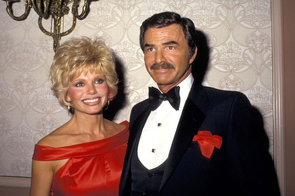 a woman and a man stand together and embrace while wearing formal attire and smiling