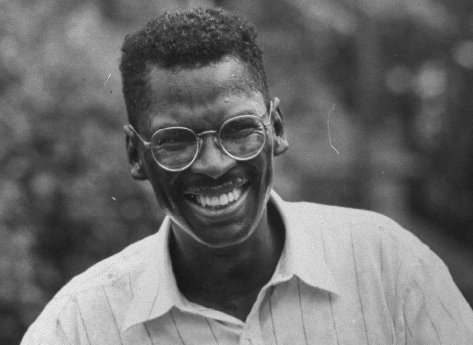 black and white image of lonnie johnson smiling past the camera