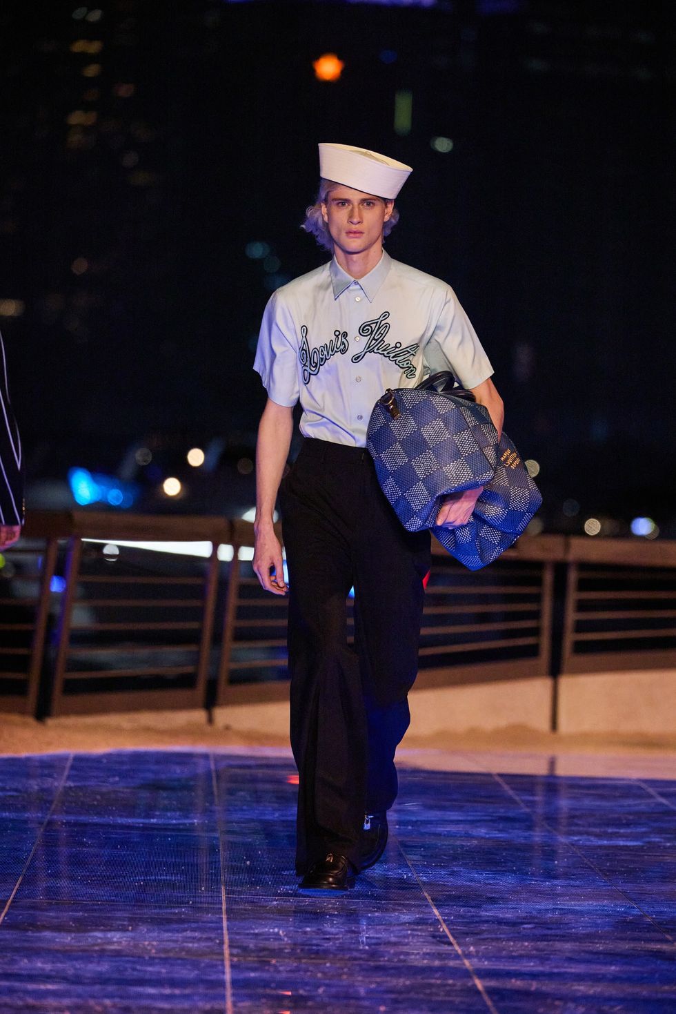 a man wearing a hat and holding a bag