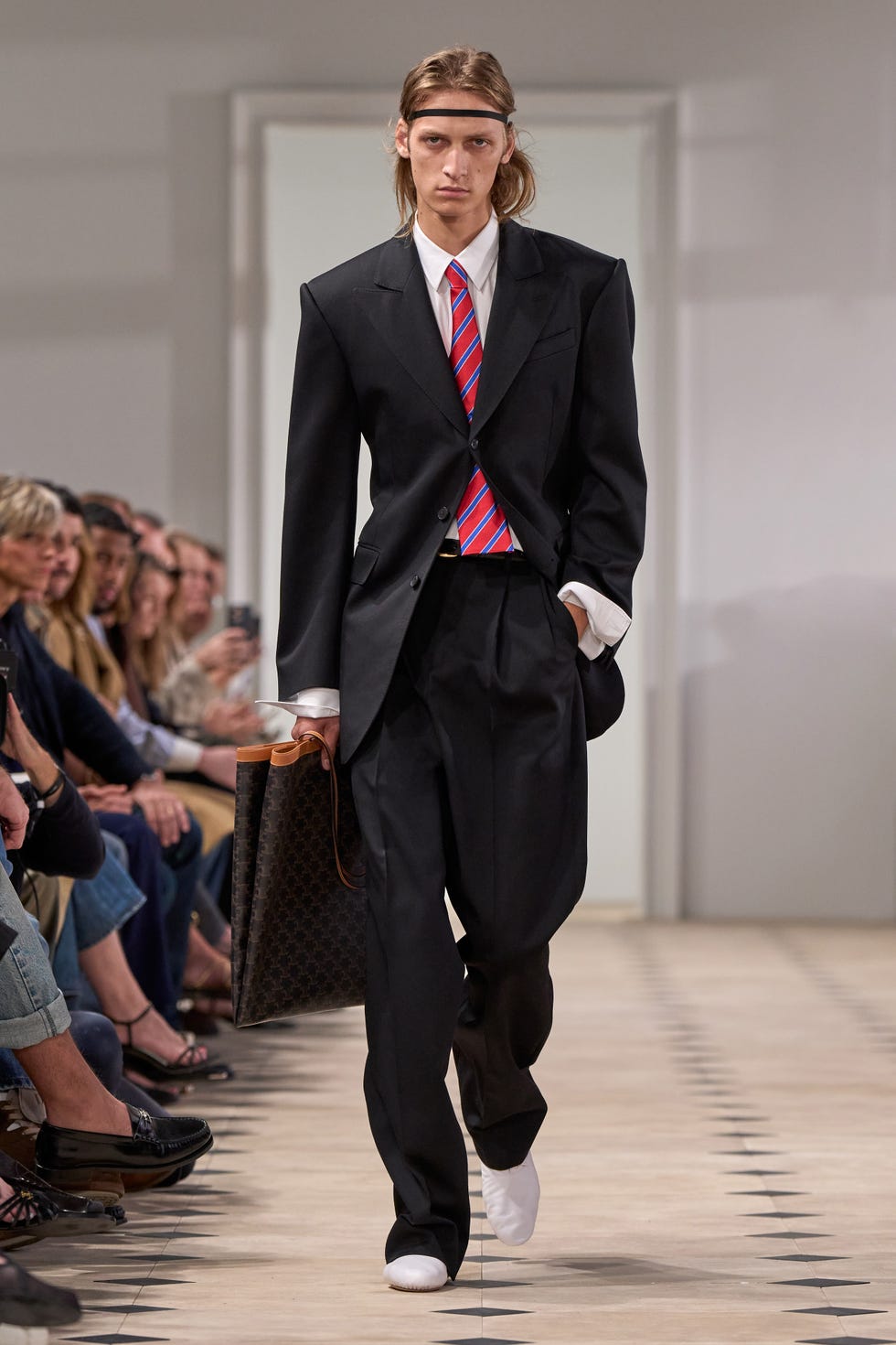 model walking the runway in a stylish suit