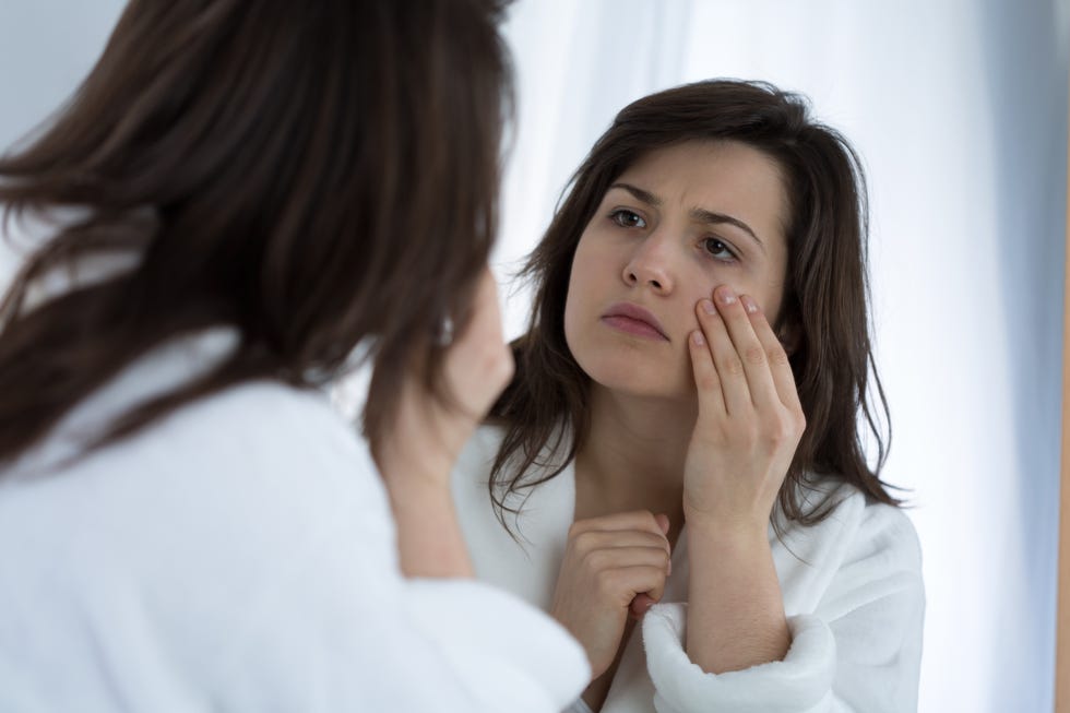 midlife crisis signs  woman looking at wrinkles