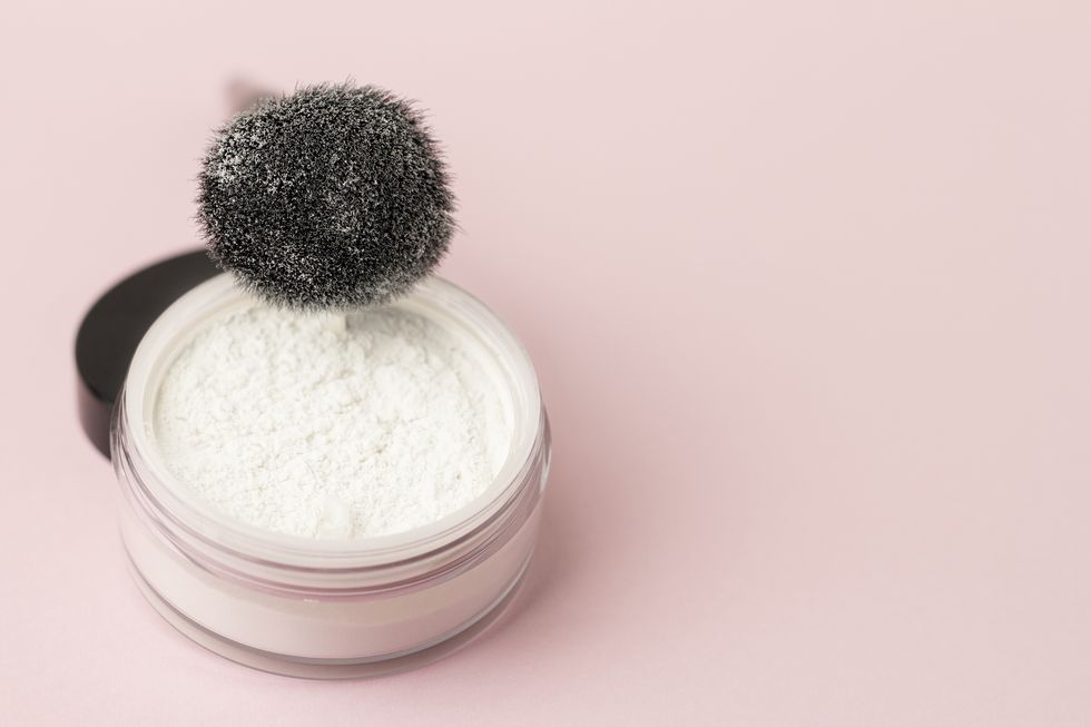 loose white face powder with black brush professional cosmetics