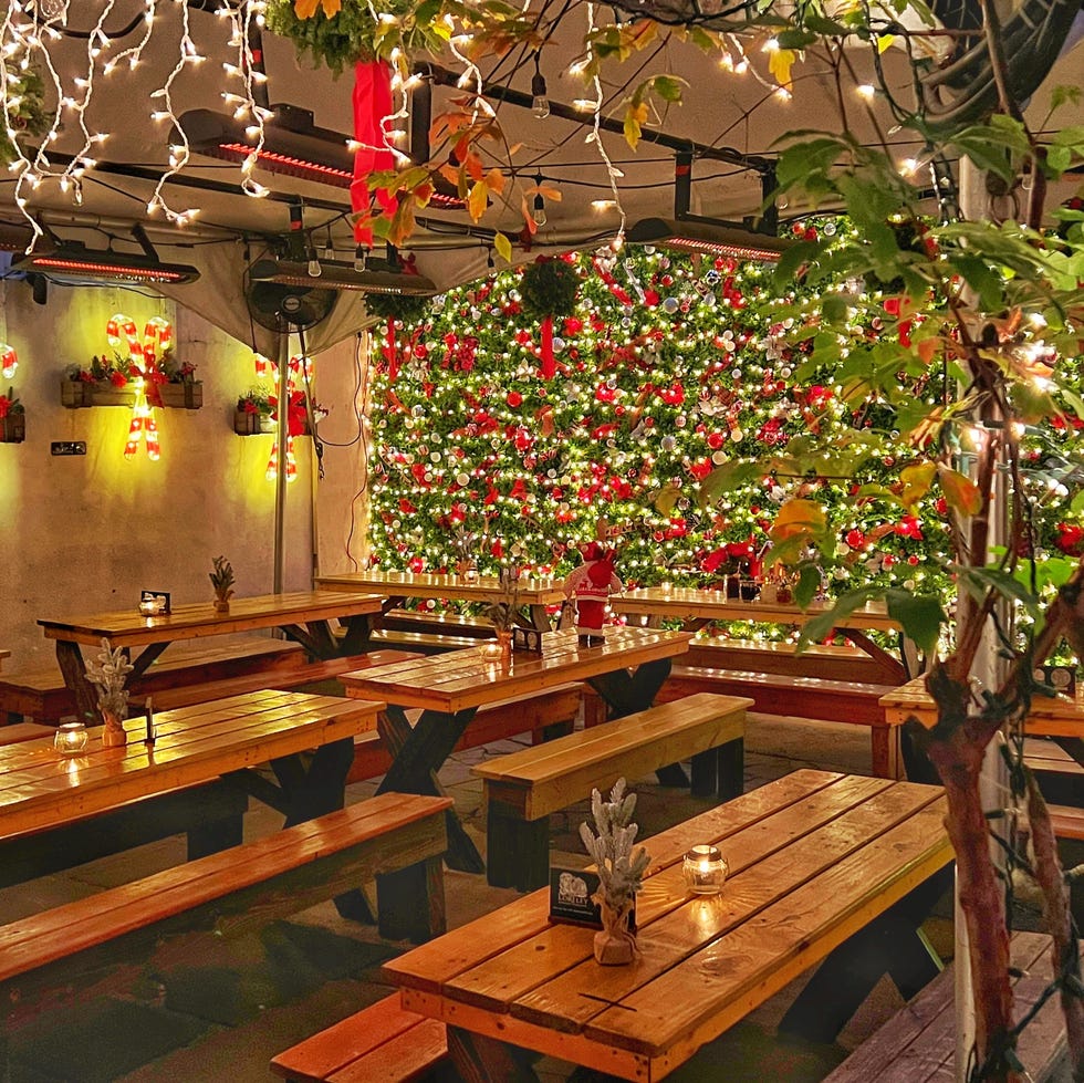 a room with tables and chairs and trees with lights