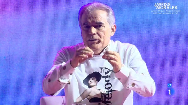 an individual presenting on stage wearing a shirt with bold graphics