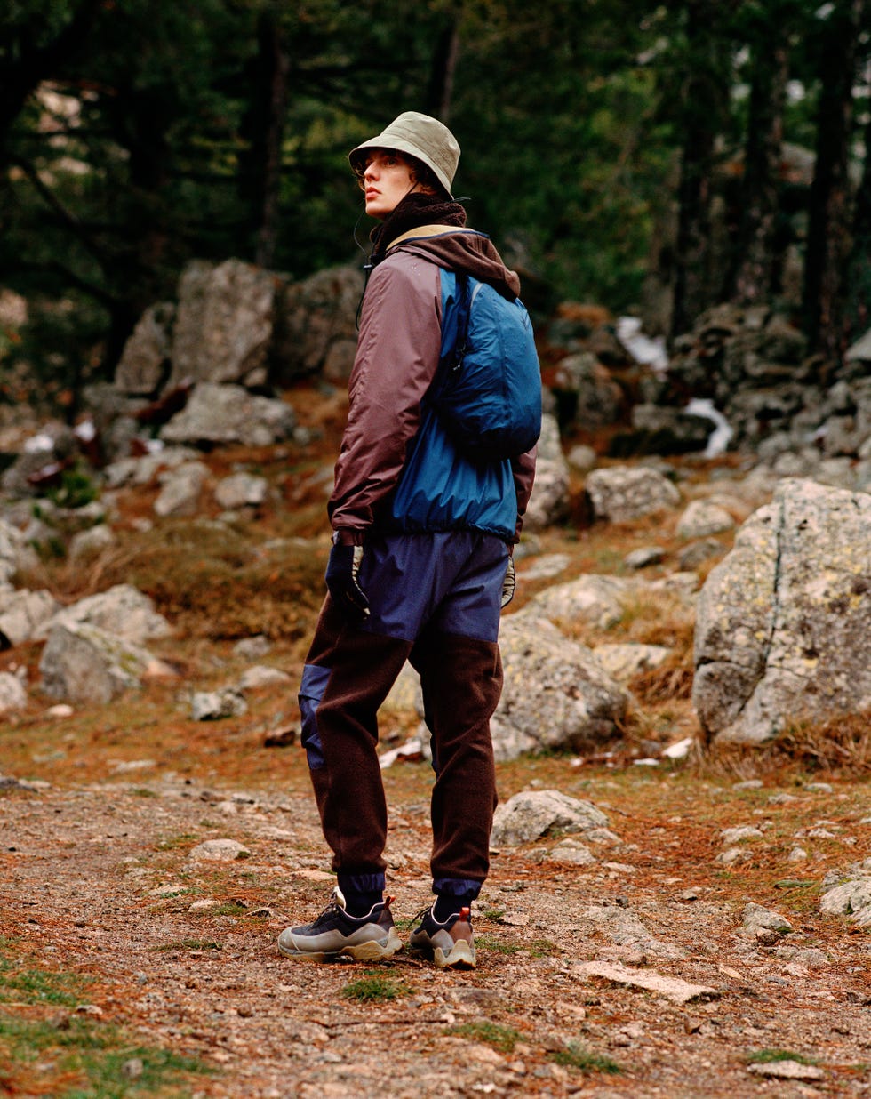 a man standing on a path in the woods