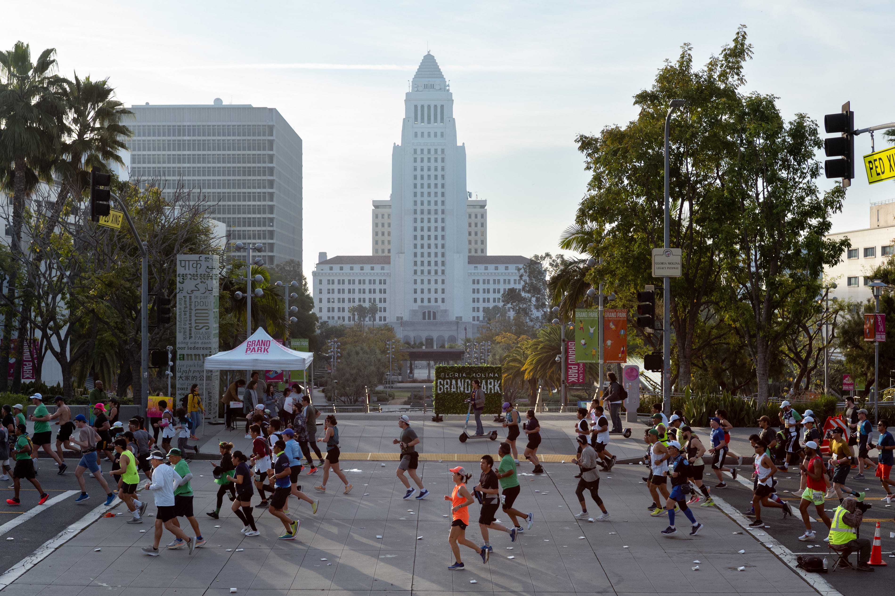 a crowd of runners pass by a large building