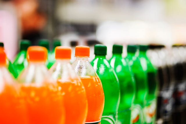 lots of soda bottles in various flavours all lined up