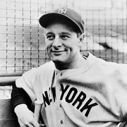 Lou Gehrig Leans Against Wall (Original Caption) Photograph of Lou Gehrig, New York, Yankees baseball star, leaning against a wall and holding a bat, and smiling.