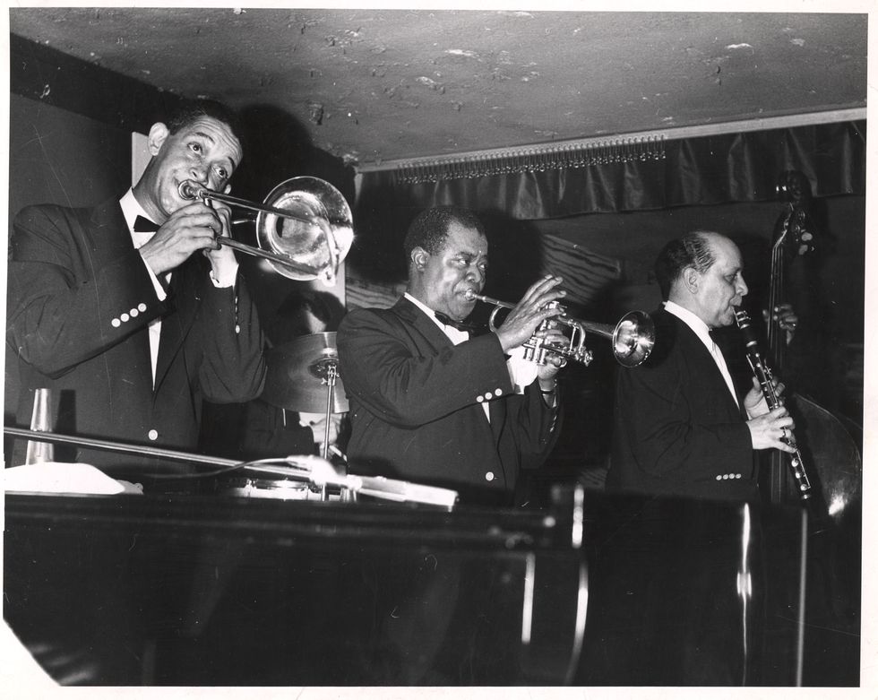 louis armstrong playing a trumpet with his bandmates