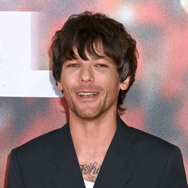 louis tomlinson smiling for photographers at a premiere event