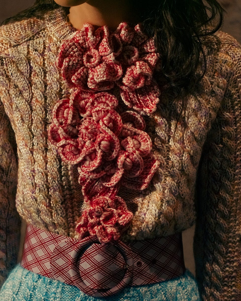 a knitted sweater with floral embellishments paired with a patterned belt louis vuitton cruise show 2026