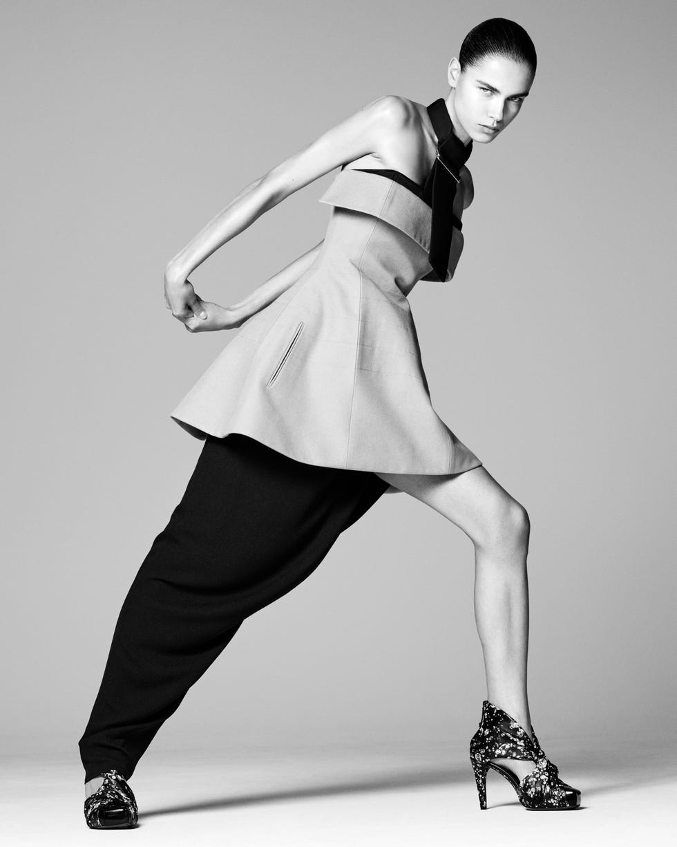 a model wearing a unique asymmetrical outfit striking a dynamic pose