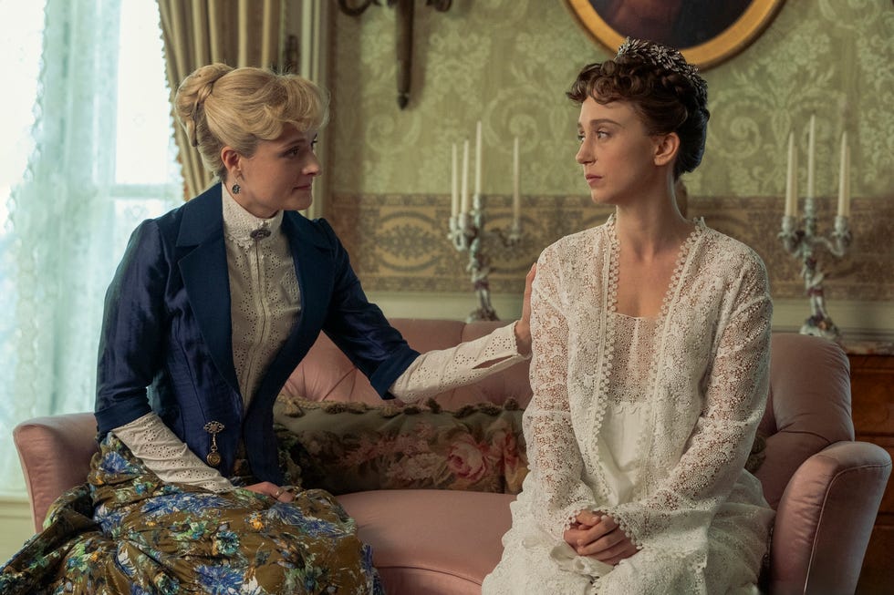 two elegantly dressed women seated in a luxurious interior