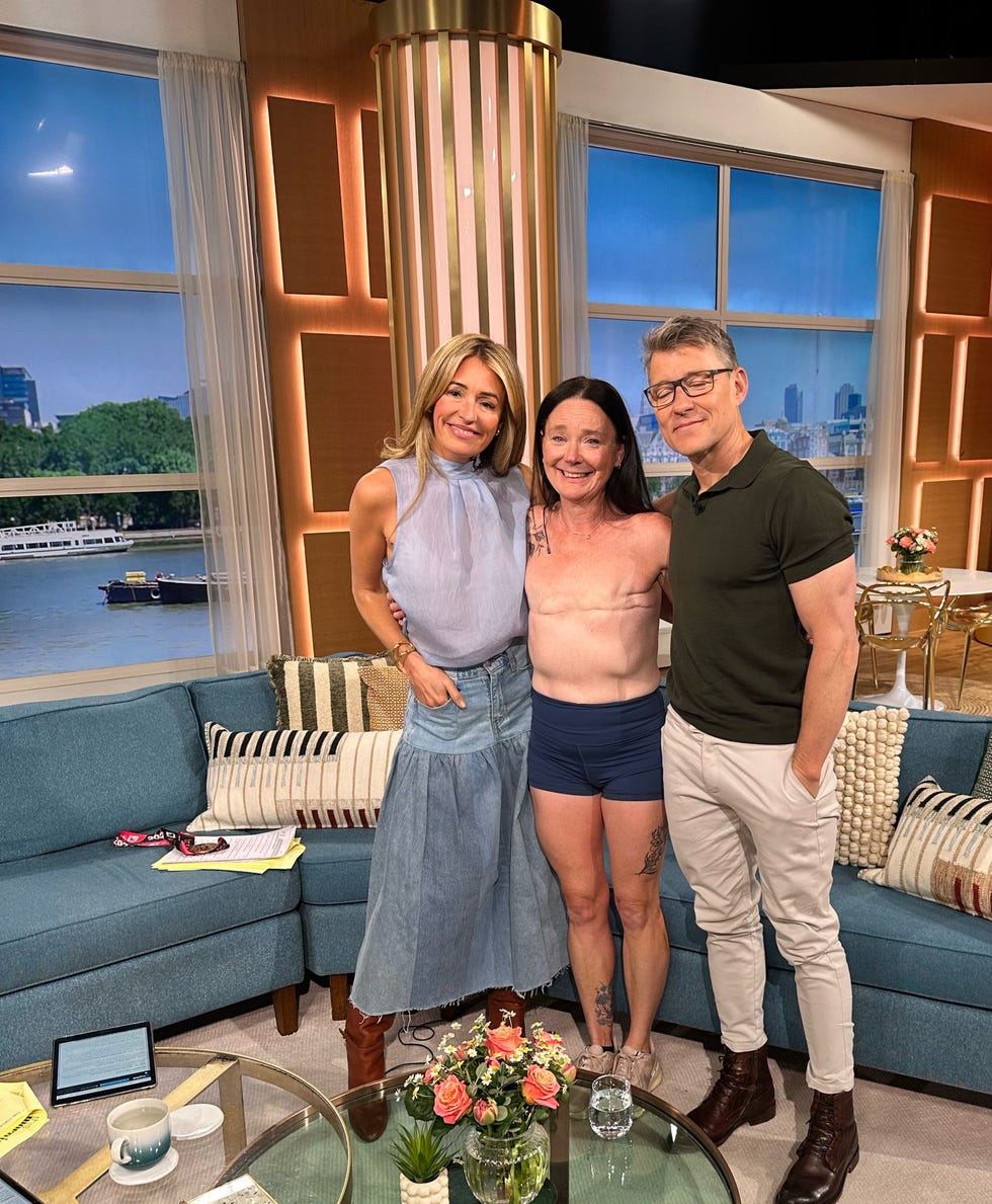 three individuals on a television studio set posing together with a cozy seating arrangement in the background