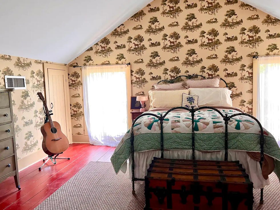 a bedroom with a bed and a guitar