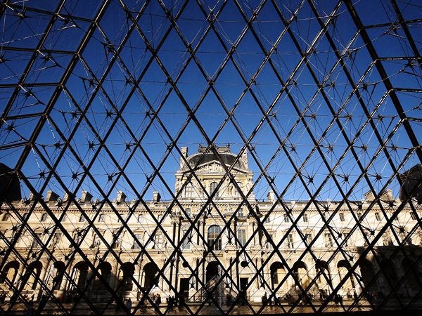 Het Louvremuseum in Parijs gezien door de glazen ingangspiramide