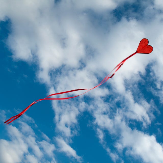 Red balloon floating in a blue sky