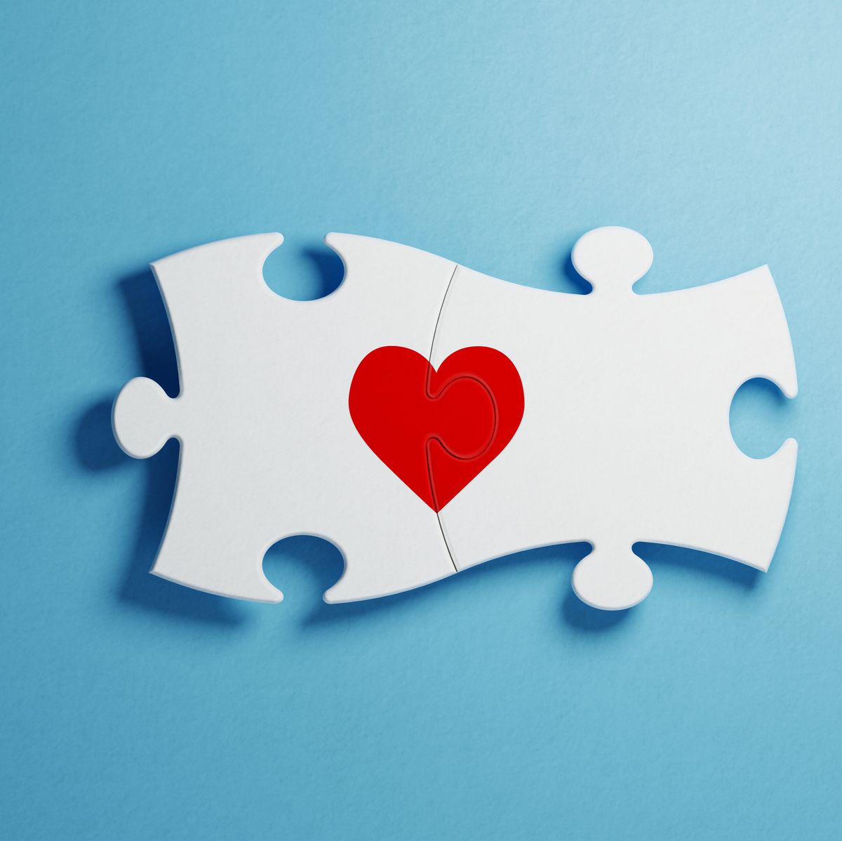 Love And Puzzle Concept - White Jigsaw Puzzle Pieces Forming A Red Heart