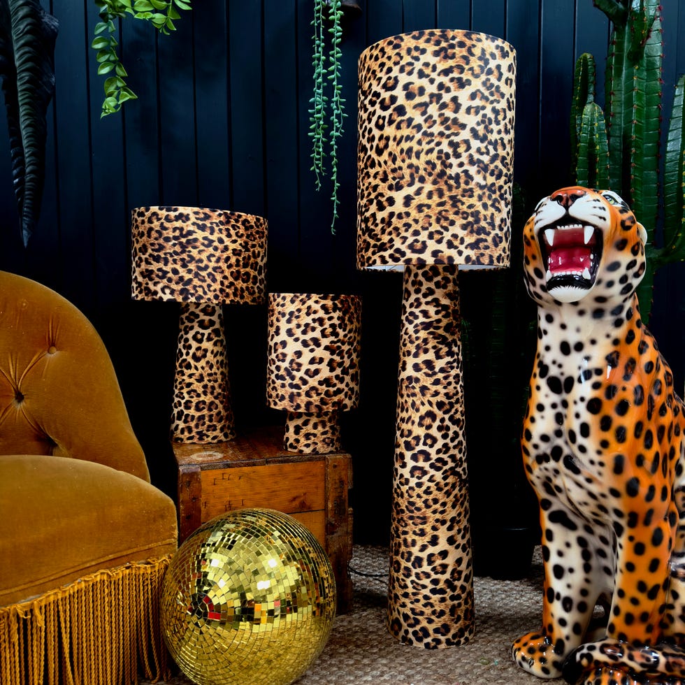 three leopard print lamps and a leopard stature and gold disco ball