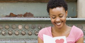 african woman reading valentines day card