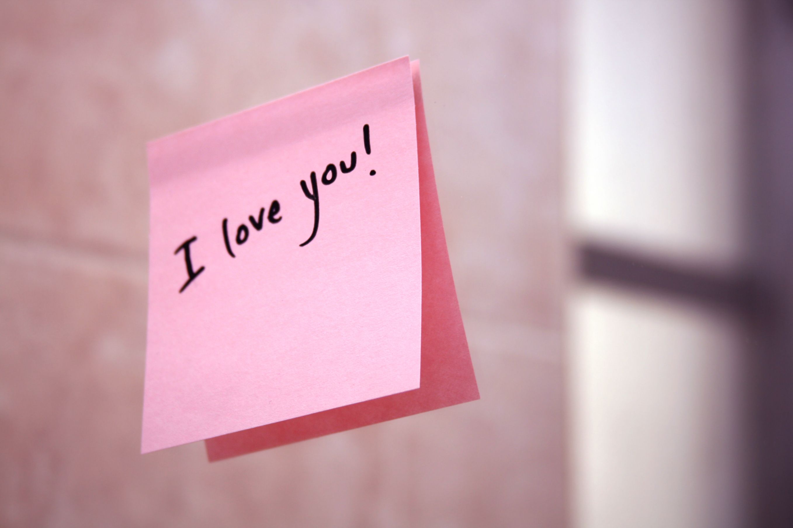I love you pink post it note stuck to the wall