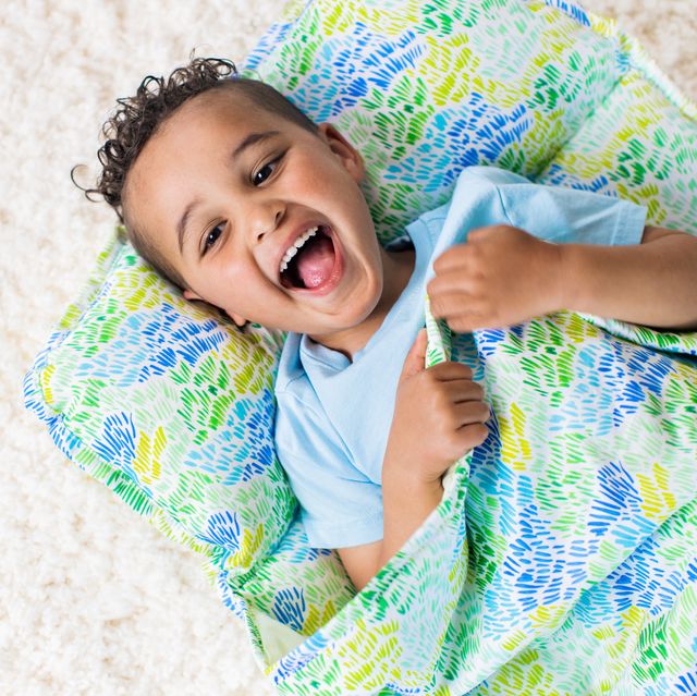 kid in nap mat that is blue and green and yellow