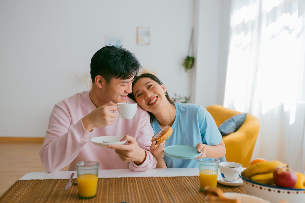 loving asian couple having breakfast together at home