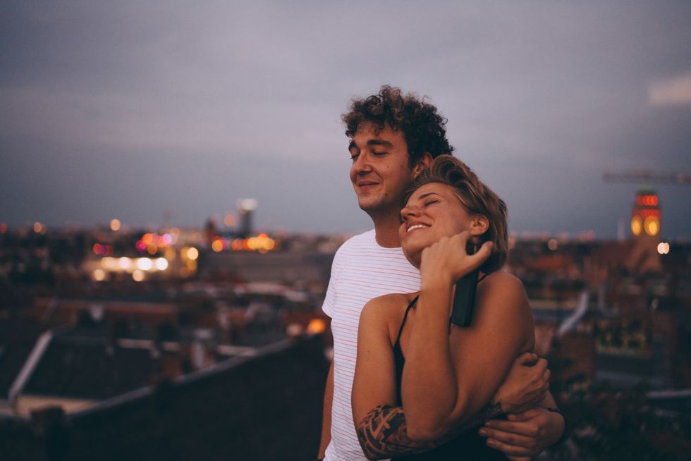 loving couple embracing while standing on terrace against sky at dusk