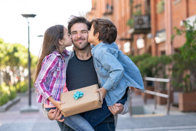 padre feliz recibiendo regalo de sus hijos