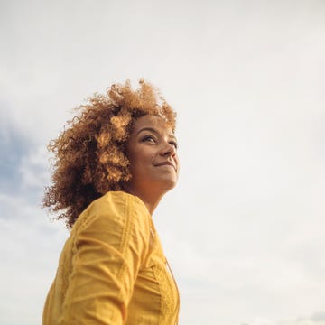 low angle portrait of beautiful woman against sky