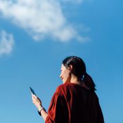 woman using phone with sky in the background
