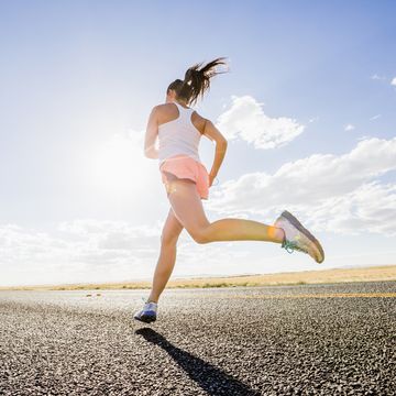 low angle view of caucasian woman running on remote road