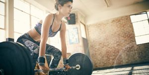 vrouw in sportkleding doet deadlift met zware gewichten