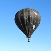 Low Angle View Of Hot Air Balloon Flying In Clear Blue Sk