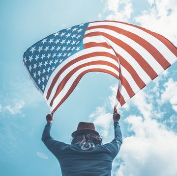 low angle view of man against sky holding american flag